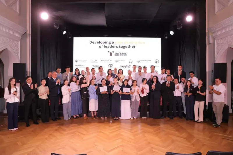 Graduates of the first cohort with guests on stage at the graduation event